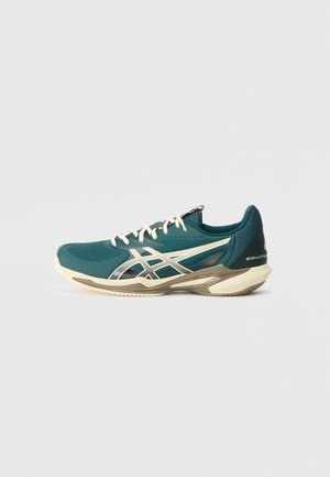 Teal Sportlichkeitsschuhe mit Obermaterial aus Mesh, cremefarbenen Akzenten und einer flexiblen weißen Sohle mit strukturierten Rillen für Traktion.