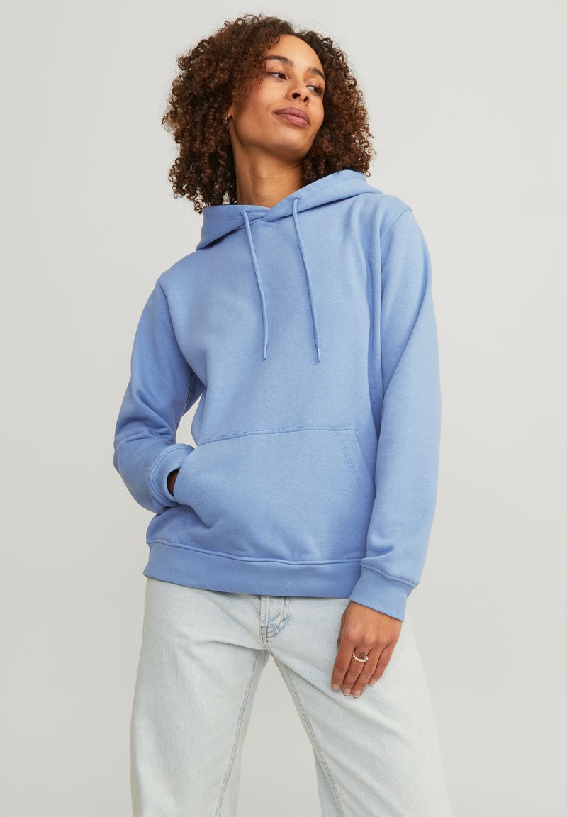 Light blue hoodie with adjustable drawstrings, front pouch pocket, and ribbed cuffs, paired with light jeans. Casual design, soft fabric.