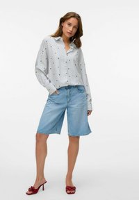 Gestreept overhemd met stippen, lichtblauwe denimshorts en rode gehakte sandalen. Relaxte fit, lange mouwen en zachte stoftextuur.