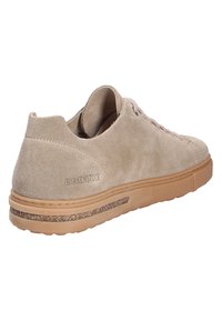 Baskets en daim beige avec une pointe ronde, un laçage, et une semelle en caoutchouc. Présentent un accent texturé le long de la semelle et un logo embouti.