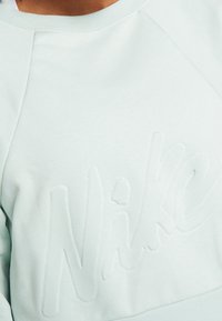 Mintgroene sweatshirt met textuur 'Nike' logo, met een ronde halslijn en raglanmouwen, gemaakt van een zachte katoenmix.