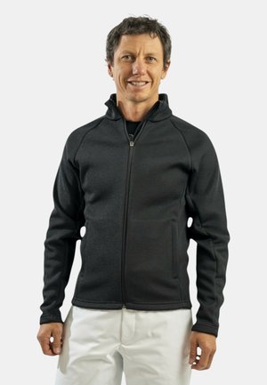 Giacca nera con zip in tessuto strutturato, caratterizzata da un alto colletto e due tasche laterali, con un design aderente e motivi a coste.