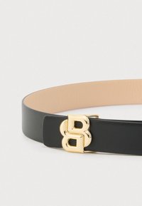 Čierny kožený opasok so zlatou prackou v tvare dvojitého "B", s hladkou textúrou a minimalistickým dizajnom. Vnútro je béžové.