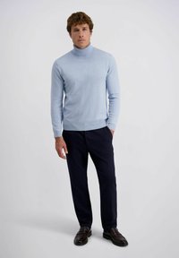 Lichtblauwe coltrui van zachte stof, slim fit. Gecombineerd met donkerblauwe broek en bruine instappers. Eenvoudig ontwerp met geribbelde accenten.