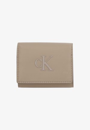 Cartera de cuero beige con un acabado texturizado, que presenta un logo "cK" en relieve en el frente y bordes cosidos. Forma compacta y rectangular.