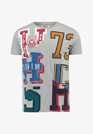 T-shirt gris à manches courtes avec de grandes lettres et chiffres colorés en blocs rouges, bleus, jaunes et verts, affichant les mots "Denim" et "Hilfiger".