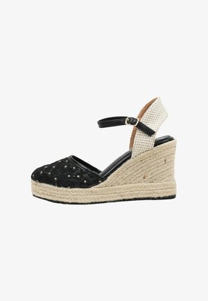 Alpargata de cuña negra con suela de cuerda beige, correa en el tobillo y soporte de talón blanco texturizado.