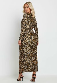 Maxiklänning med leopardmönster, långa ärmar, figursydd midja och något utställd fåll, tillverkad av ett slätt tyg i jordnära färger.