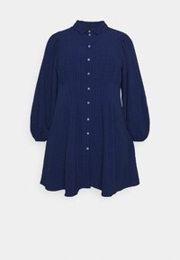 Tummansininen ruudullinen mekko, jossa on kaulus, pitkät puffihihat ja etupainonappi. Valmistettu kevyestä kankaasta, joka on rento malli.