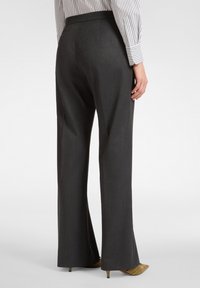 weit geschnittene, dunkelgraue Hosen mit taillierter Passform. Aus strukturiertem Stoff mit glatter Oberfläche, ausgestattet mit einem klassischen Taillenbund und seitlichen Taschen.