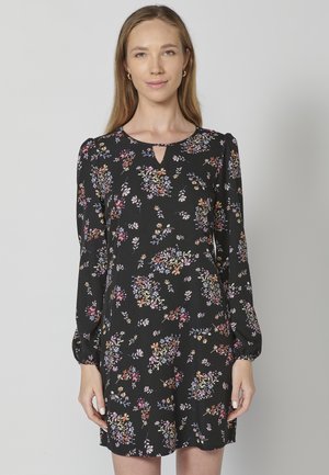 Abito nero a fiori con maniche lunghe a sbuffo, scollo a chiave e una vestibilità rilassata con motivi floreali colorati.