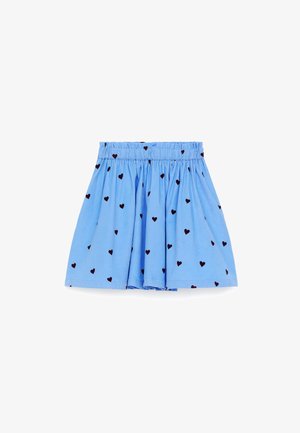 Jupe bleue froncée avec motif de cœurs noirs et taille élastique.