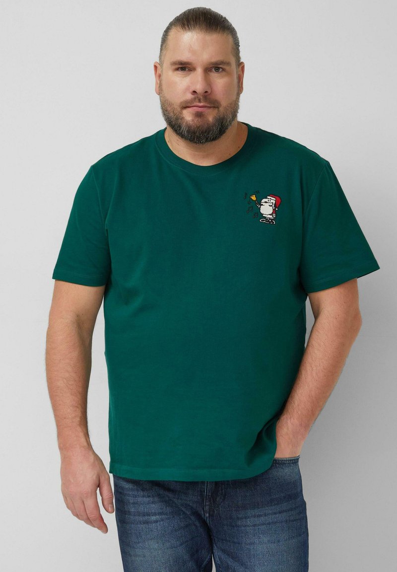 Grünes Baumwoll-T-Shirt mit kurzen Ärmeln, mit einem bestickten Snoopy in einem roten Hut, der eine Trompete hält, und musikalischen Noten nahe dem Halsausschnitt.