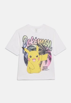 Wit T-shirt met kleurrijke "Pokémon"-tekst, Pikachu die zwaait, silhouetten van palmbomen en de slogan "Gotta Catch 'Em All!"