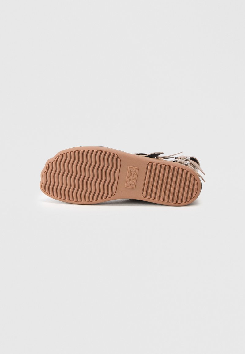 Brown rubber sandal sole with textured grooves, featuring a logo imprint, and a contoured design for grip.