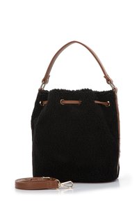 Sac seau en fausse fourrure noire avec poignées en cuir marron et bandoulière. Présente des œillets en métal pour un système de fermeture à cordon.