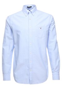 Lichtblauw overhemd met lange mouwen, gemaakt van katoen, voorzien van een button-down kraag, een borstzak en subtiele branding op de zak.