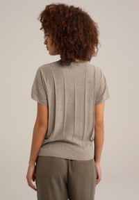 Grå texturerad stickad tröja med korta ärmar, med vertikal ribbad design och en åtsittande midja, kompletterad med en enkel rund halsringning.