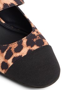 Leopard print flat shoe with a black rubber sole. Features a textured brown and black upper with a velcro strap across the instep.