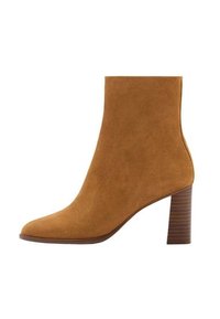 Bottine en daim beige avec un bout pointu et un talon bloc empilé.