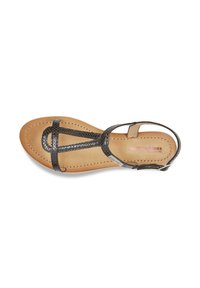 Black leather sandal with a flat sole, featuring a T-strap design and adjustable ankle buckle. Beige insole with stitching detail.