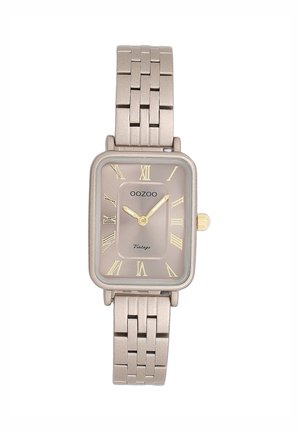 Montre rectangulaire beige avec un bracelet en maille métallique, dotée d'un cadran doré, de chiffres romains et d'une couronne dorée. Texte "OOZOO Vintage" affiché.