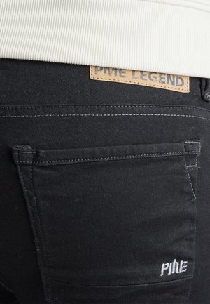 Črne denim hlače z usnjenim etiketom, ki nosi napis "PME LEGEND." Detajli šivanja so vidni na žepih, s subtilno teksturo in obliko slim fit.