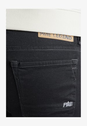 Pantalons en denim noir avec une étiquette en cuir arborant "PME LEGEND." Détails de couture visibles sur les poches, avec une texture subtile et une coupe slim.