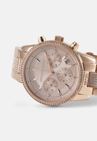 Montre-bracelet Michael Kors en or rose avec lunette et bracelet sertis de cristaux, trois sous-cadrans et date réglée au 15.