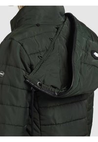 Padded green jacket with a high collar, detachable hood, drawstring, and black accents. Textured surface with a quilted pattern.