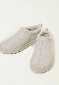 Light gray slip-on shoes with a textured felt upper, elastic trim, and a lightweight, cushioned sole. Two pull tabs for easy wear.