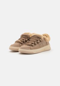 Sneaker in suede marrone con foderatura in pelliccia sintetica beige, lacci testurizzati e suola in gomma con accenti minimi. Design low-profile.