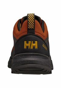 Zapatilla de senderismo negra y naranja con un upper texturizado, que presenta un logo amarillo y una suela de goma, incluyendo un talón reforzado y una pestaña de agarre.