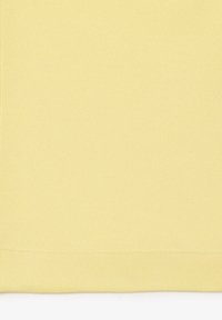 Világos sárga szövet, texturált szövésű, alján tiszta éllel, amely különböző textil alkalmazásokhoz alkalmas.