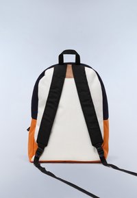 Sac à dos de forme arrondie ; fabriqué en tissu de couleur blanche, marine et orange ; dispose de bretelles noires et d'une poignée supérieure ; texture lisse.