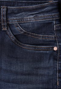 Donkere denim jeans met een soepele textuur en gouden stiksels. Voorzien van een voorzak en een metalen knoopaccent.