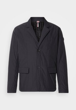 Veste noire texturée avec un col à revers, deux poches avant et deux boutons. Design léger avec une doublure intérieure lisse.