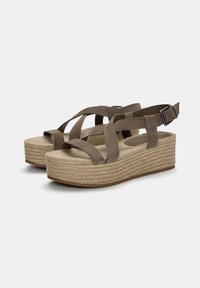 Braune Wildleder-Plateausandalen mit überkreuzten Riemen, einer Espadrille-ähnlichen gewebten Jutesohle in der Mitte und einer verstellbaren Knöchel-Schnalle. Flache Gummisohle.