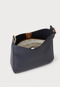 Borsa in pelle blu navy con una superficie liscia, caratterizzata da un accento in pelle marrone e un interno con zip. Il design open-top rivela un rivestimento di colore chiaro.