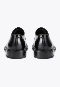 Scarpe in pelle lucida nera con punta arrotondata, tacco basso e texture liscia. Caratteristiche includono cuciture minime e un design classico.