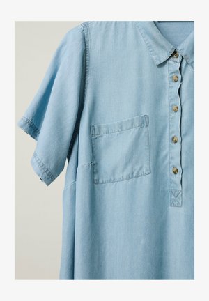 Camicia azzurro chiaro a maniche corte con colletto, taschino sul lato sinistro e cinque bottoni marroni sulla patta frontale.