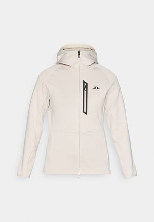 Lys beige zip-jakke med hette og svarte detaljer. Har en frontlomme med glidelås og glatt, litt teksturert stoff.