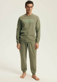 Olive green sweatshirt with "CHOOSE YOUR PATH" text, paired with matching jogger pants. Both made of soft, smooth fabric with ribbed cuffs.