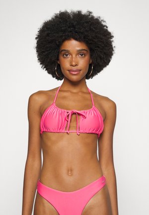 Conjunto de biquíni cor-de-rosa, featuring um topo de halter com franzido e laço frontal, e parte de baixo de cintura alta. Tecido suave e elástico com detalhes de hardware mínimos.