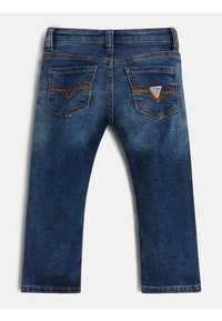 Vaqueros azul oscuro de corte recto, con bolsillos traseros curvados, costura naranja y una pequeña etiqueta de logo en el bolsillo derecho.