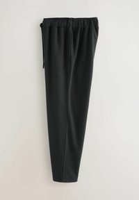 Zwarte, gestructureerde joggers met een elastische tailleband en trekkoord, voorzien van een taps toelopend ontwerp en een zachte stofafwerking.