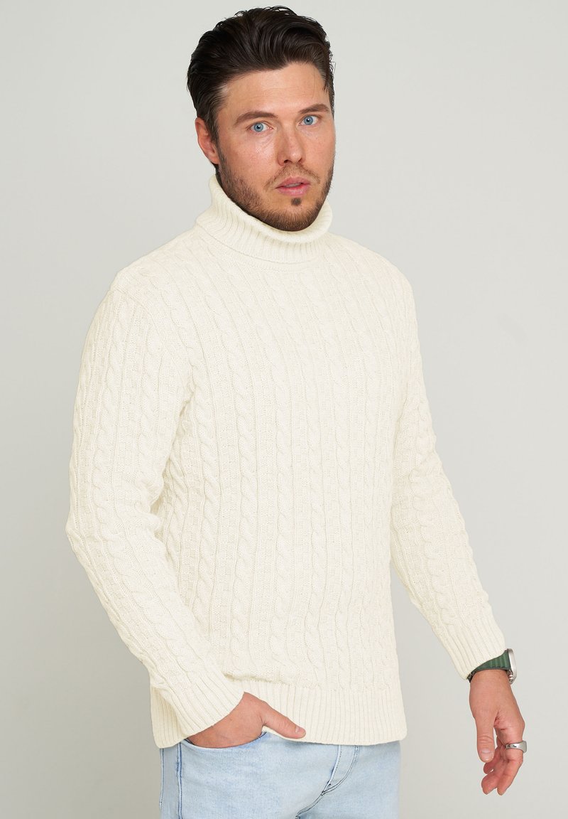 Cremfarbener Rollkragenpullover aus Kabelstrick mit gerippten Bündchen und Saum. Verfügt über ein strukturiertes Muster und einen lockeren Schnitt.