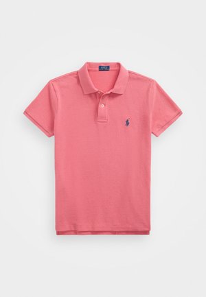 Rosa polo med klassisk krage, korte ermer, to-knaps placket og blå brodert logo på venstre bryst. Stoffet er laget av bomull.