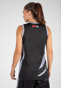 Zwarte mouwloze top met grijze accenten, met een logo op de achterkant. De stof lijkt lichtgewicht en soepel, met een gestroomlijnd design.