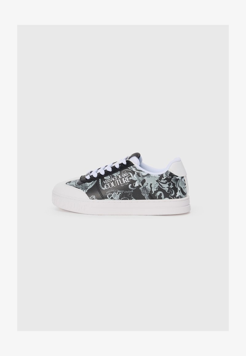 Črno-bela teniška obutev s cvetličnim vzorcem, bela podplat in vezalke. Na strani ima logo "VERSACE JEANS COUTURE".